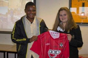 Henry receiving the signed Saint shirt from Rosie Patton